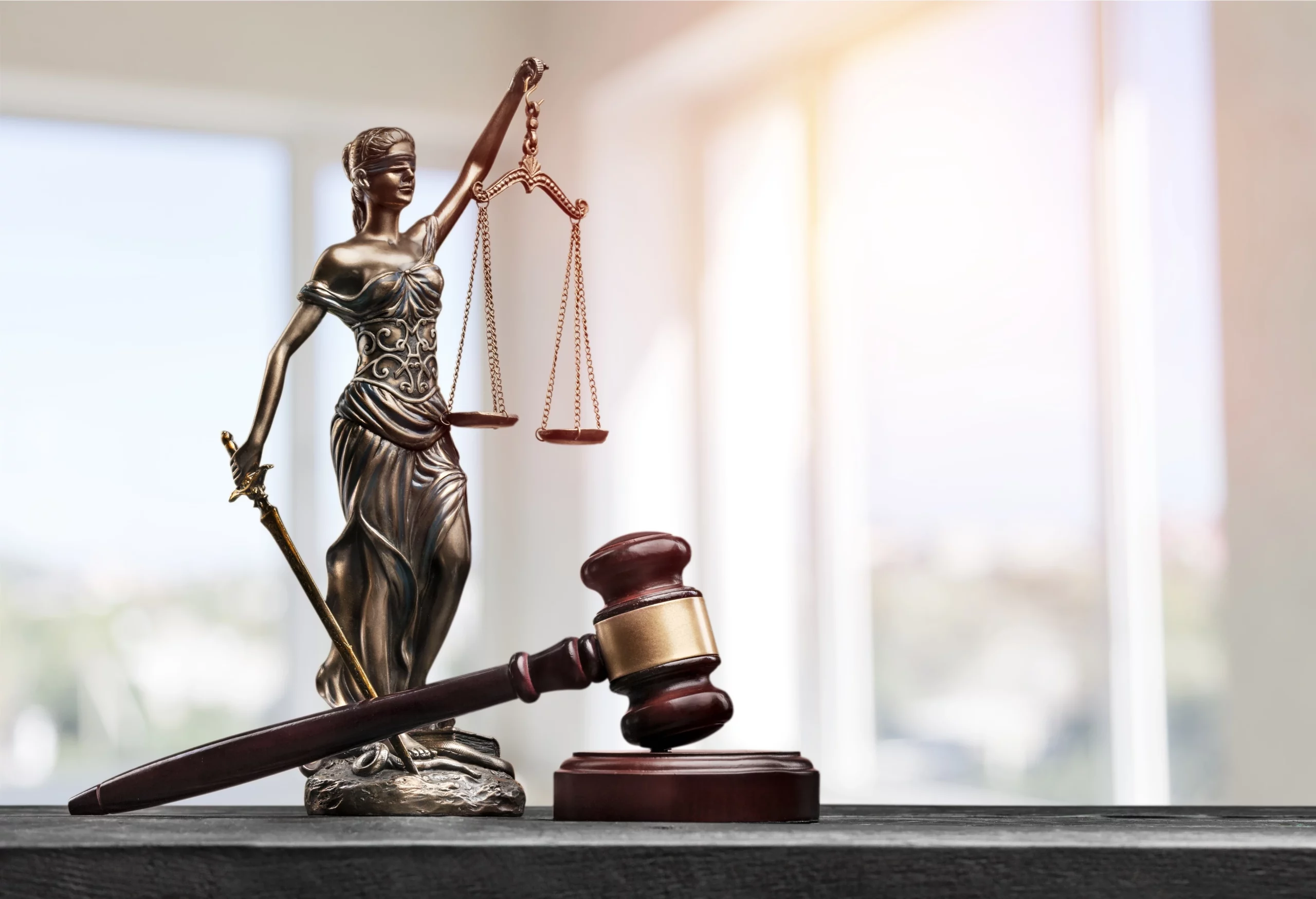 Lady Justice holding scales beside a judge’s gavel